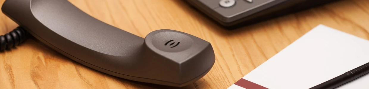 En telefonmottaker på et trepult som symboliserer kommunikasjon og støtte. Kontakt oss på barnesakkyndig.no.