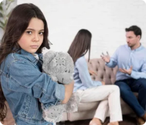 Et barn holder en bamse og ser trist ut mens to voksne krangler i bakgrunnen, noe som illustrerer utfordringer i barnefordelingssaker og betydningen av å ivareta barnets beste.