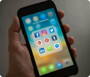 En hånd som holder en smarttelefon med apper for sosiale medier som Facebook, Instagram, Snapchat og TikTok – illustrerer barns bruk av digitale medier og behovet for digital foreldrerolle.